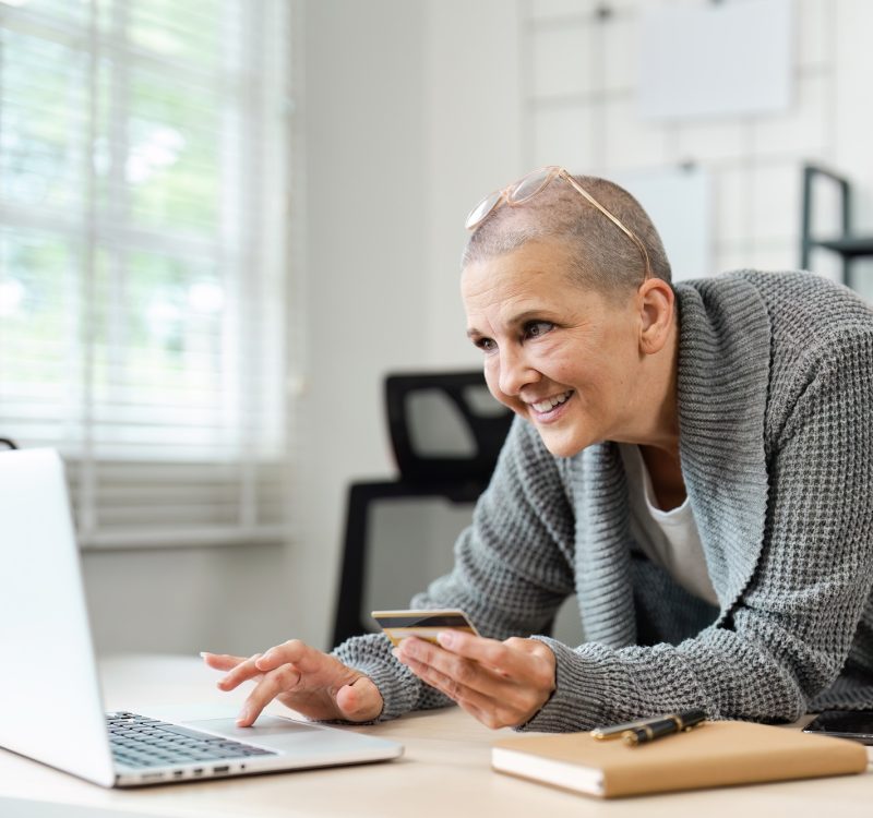 Senior Woman Shopping Online with Credit Card and Laptop in Modern Home Office Setting